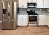Thumbnail 5 of 13 - a kitchen with stainless steel appliances and white cabinets