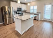 Thumbnail 6 of 13 - an open kitchen with an island and stainless steel appliances