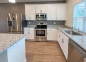 Thumbnail 7 of 13 - a kitchen with white cabinets and stainless steel appliances