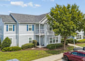 Thumbnail 1 of 35 - A two-story house with a red car parked in front.
