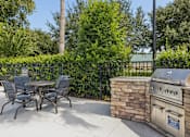 Thumbnail 16 of 35 - A patio with a grill and chairs.