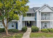 Thumbnail 3 of 35 - A two-story house with a blue door and a balcony.