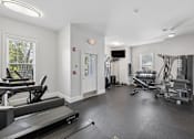 Thumbnail 20 of 35 - A spacious gym with treadmills, weights, and exercise equipment.