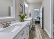 Thumbnail 28 of 47 - A bathroom with two sinks and a mirror.