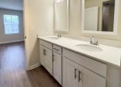 Thumbnail 12 of 13 - an empty bathroom with two sinks and a mirror