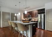 Thumbnail 82 of 91 - A modern kitchen with a large island and stainless steel appliances.