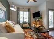 Thumbnail 79 of 91 - A living room with a white couch and a black coffee table.