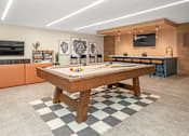 Thumbnail 27 of 91 - A room with a checkered floor and a wooden table in the center.