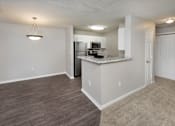 Thumbnail 33 of 43 - an empty living room and kitchen with a counter top and a refrigerator