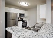 Thumbnail 35 of 43 - a kitchen with granite counter tops and stainless steel appliances
