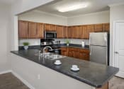 Thumbnail 37 of 50 - an empty kitchen with stainless steel appliances and wooden cabinets