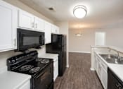 Thumbnail 38 of 43 - an empty kitchen with white cabinets and black appliances