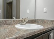 Thumbnail 56 of 91 - A bathroom sink with a granite counter top.