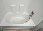 Thumbnail 49 of 91 - A white bathtub with a silver faucet and a silver handle.