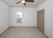 Thumbnail 52 of 91 - A room with a ceiling fan and a door.