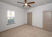 Thumbnail 36 of 91 - A room with a ceiling fan and two doors.