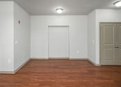 Thumbnail 39 of 91 - A room with a wooden floor and a white door.