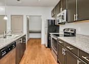 Thumbnail 44 of 91 - A kitchen with dark brown cabinets and stainless steel appliances.