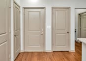 Thumbnail 40 of 91 - A hallway with three doors and a white counter.