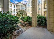 Thumbnail 58 of 91 - A view of a courtyard with a tree and a bench.
