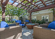 Thumbnail 16 of 91 - A patio with brown wicker furniture and a wooden pergola.