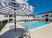 Thumbnail 26 of 46 - our apartments have a large pool and patio with chairs and an umbrella