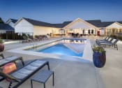 Thumbnail 12 of 50 - a swimming pool with lounge chairs and tables in front of a house