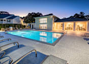 Thumbnail 12 of 43 - a swimming pool with chairs around it in front of a house