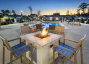 Thumbnail 13 of 50 - an outdoor patio with a fire pit and chairs