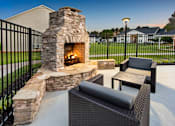 Thumbnail 13 of 43 - an outdoor patio with a stone fireplace and a table and chairs