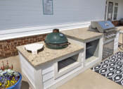 Thumbnail 16 of 50 - an outdoor kitchen with a grill and a counter with a pot on it