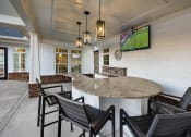 Thumbnail 19 of 50 - a kitchen with a bar with chairs and a tv