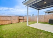 Thumbnail 13 of 13 - a backyard with a patio and a fence and grass