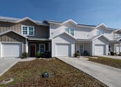 Thumbnail 7 of 47 - A row of houses with garages and front yards.