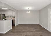 Thumbnail 29 of 62 - A kitchen with white cabinets and a wooden floor.