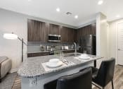 Thumbnail 13 of 73 - a kitchen with a large island with a granite countertop  at Scottsdale Hayden Townhomes, Arizona