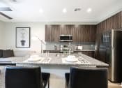 Thumbnail 15 of 73 - a kitchen and living room with a large island with a granite countertop  at Scottsdale Hayden Townhomes, Scottsdale, 85257