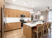 Thumbnail 16 of 81 - A kitchen with wooden cabinets and a white countertop.