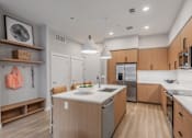 Thumbnail 15 of 81 - A modern kitchen with wooden cabinets and a white island.