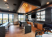 Thumbnail 78 of 81 - A modern kitchen and dining area with a wooden ceiling and black countertops.