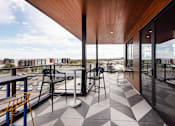 Thumbnail 74 of 81 - A balcony with a black and white checkered floor and a yellow chair.