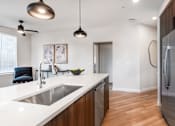 Thumbnail 5 of 81 - A modern kitchen with a stainless steel refrigerator and a white countertop.