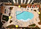 Thumbnail 60 of 81 - An aerial view of a pool surrounded by chairs and umbrellas.
