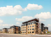 Thumbnail 63 of 81 - A row of modern apartment buildings are lined up on a street.