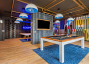 Thumbnail 46 of 81 - A room with a pool table and a TV mounted on the wall.