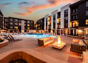 Thumbnail 2 of 81 - A pool with a fire pit in the middle of it.