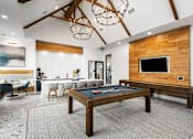 Thumbnail 35 of 52 - A billiard table is in the middle of a room with a wooden wall and a television.