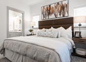 Thumbnail 10 of 52 - A bedroom with a large bed and a painting above it.