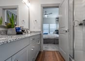 Thumbnail 27 of 52 - A bathroom with a marble countertop and a walk-in shower.