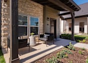 Thumbnail 29 of 52 - A house with a patio and a stone wall.